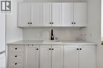 Hamilton condo for rent - A kitchen with white cabinets and a white sink.