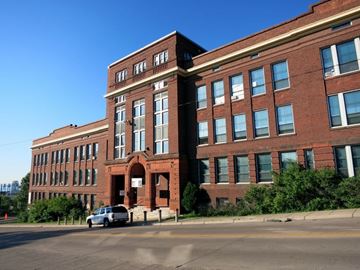Duluth apartment for rent - A large red brick building with a car parked in front.