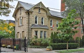 Toronto (Cabbagetown-South St. James Town) apartment for rent - A large, Victorian-style house with a black fence and a flag on the front.