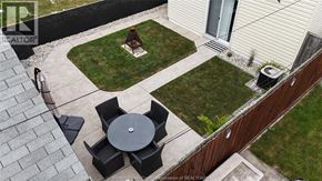 Windsor apartment for rent - A patio with a table and chairs is surrounded by a grassy area and a house.