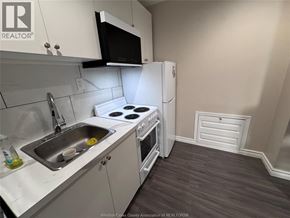 Windsor apartment for rent - A kitchen with white cabinets and a black microwave above the stove.