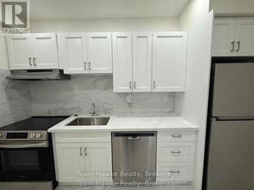 Midland multi-family for rent - A kitchen with white cabinets and a marble backsplash.
