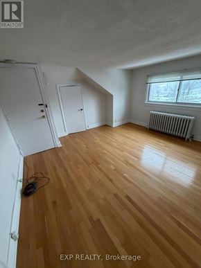 Toronto (Junction Area) multi-family for rent - A room with wooden flooring and a window with blinds.