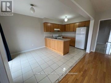 Whitby (Rolling Acres) apartment for rent - A kitchen with wooden cabinets and a white refrigerator.