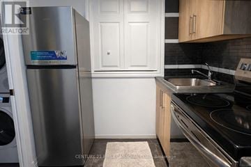 London South (South R) apartment for rent - A kitchen with a stainless steel refrigerator and a stove top oven.