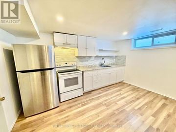 Ottawa apartment for rent - A kitchen with a stainless steel refrigerator and wooden flooring.