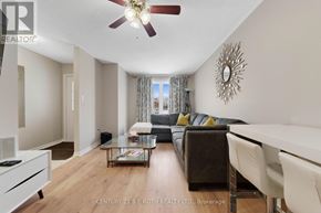 Barrie (Georgian Drive) apartment for rent - A living room with a brown couch and a ceiling fan.