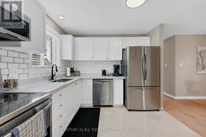 Barrie (Georgian Drive) apartment for rent - A modern kitchen with white cabinets and stainless steel appliances.