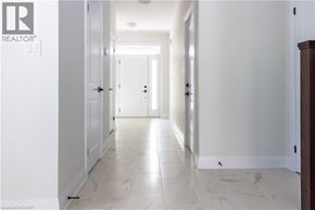 Kitchener apartment for rent - A long hallway with white walls and marble flooring.