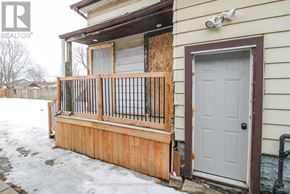 Port Colborne (East Village) multi-family for rent - A house with a boarded up window and a wooden fence.