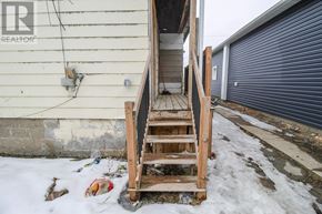 Port Colborne (East Village) multi-family for rent - A wooden staircase leading to a garage door.