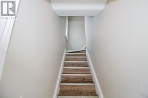 Port Colborne (East Village) multi-family for rent - A staircase with wooden steps leading up to a white landing.
