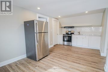 Port Colborne (East Village) multi-family for rent - A kitchen with a stainless steel refrigerator and wooden flooring.