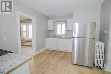 Port Colborne (East Village) multi-family for rent - A kitchen with white cabinets and a stainless steel refrigerator.