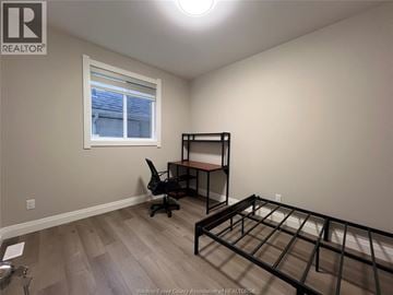 Windsor apartment for rent - A bedroom with a bed frame and a desk with a chair.