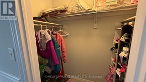 Wasaga Beach apartment for rent - A closet with clothes hanging and shoes on the shelves.