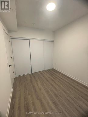 Vaughan (Vaughan Corporate Centre) condo for rent - A room with a sliding door and wood flooring.