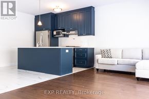 Kitchener apartment for rent - A kitchen with dark blue cabinets and a white couch.