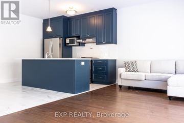 Kitchener apartment for rent - A kitchen with dark blue cabinets and a white couch.