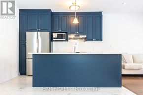 Kitchener apartment for rent - A kitchen with dark blue cabinets and a white island.