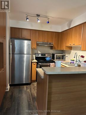 Toronto (Woburn) condo for rent - A kitchen with wooden cabinets and a stainless steel refrigerator.