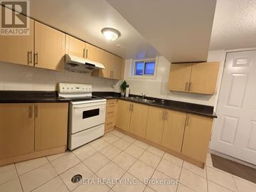 Whitby (Williamsburg) apartment for rent - A kitchen with wooden cabinets and a white stove top oven.