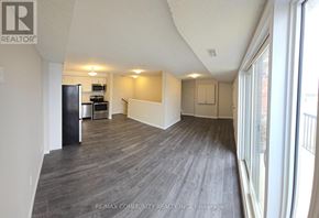 Kitchener townhouse for rent - A spacious room with wood flooring and a large window.