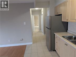 Hamilton condo for rent - A kitchen with a refrigerator, sink, and cabinets.
