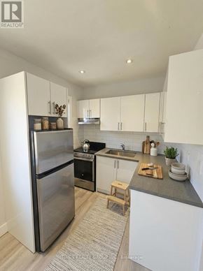 Toronto (Bedford Park-Nortown) multi-family for rent - A modern kitchen with a stainless steel refrigerator and white cabinets.