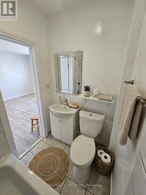 Toronto (Bedford Park-Nortown) multi-family for rent - A white bathroom with a toilet, sink, and mirror.