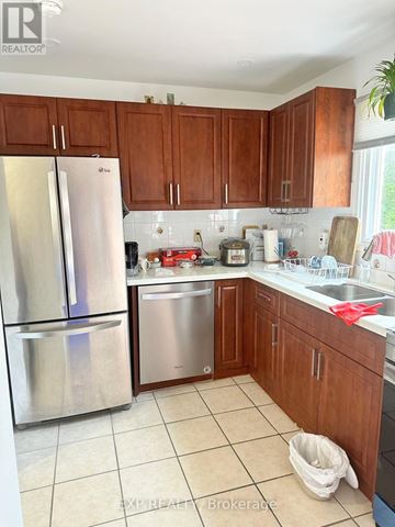 Toronto (Milliken) apartment for rent - A kitchen with a stainless steel refrigerator and wooden cabinets.