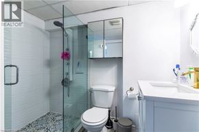 Hamilton apartment for rent - A white toilet with a glass shower stall in the background.