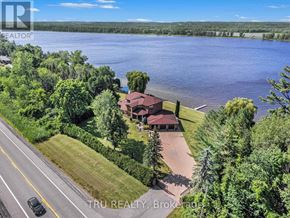 Ottawa apartment for rent - A house with a red roof is surrounded by greenery and a body of water.