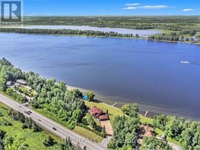 Ottawa apartment for rent - A bird's eye view of a lake surrounded by greenery and a road with vehicles.
