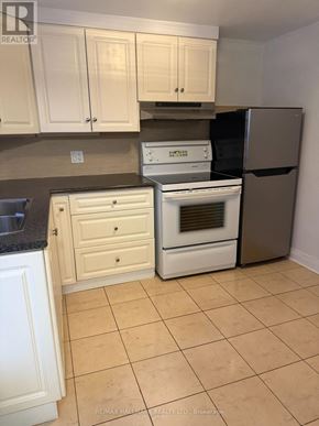 St. Catharines (Downtown) duplex for rent - A kitchen with white appliances and cabinets.