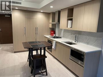 Vancouver apartment for rent - A modern kitchen with a table and chairs.