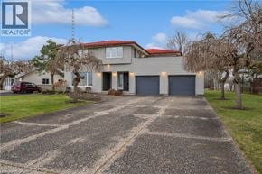 Fort Erie apartment for rent - A house with a red roof and a driveway in front of it.