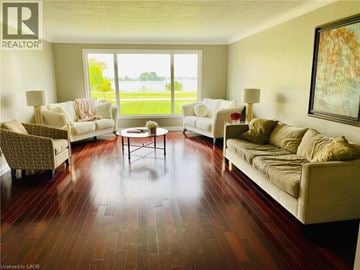 Fort Erie apartment for rent - A living room with a large window and a painting on the wall.