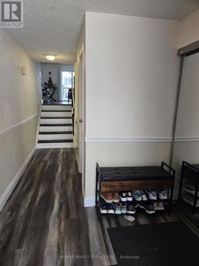 Kitchener townhouse for rent - A hallway with a bench and shoes on the floor.