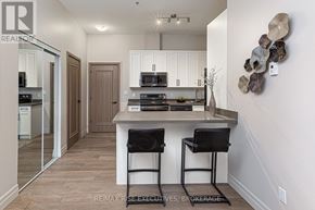 Kingston (South Of Taylor-Kidd Blvd) condo for rent - A modern kitchen with white cabinets and a wooden floor.