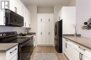 Kingston (South Of Taylor-Kidd Blvd) condo for rent - A modern kitchen with black appliances and white cabinets.
