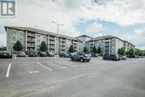 Kingston (East Gardiners Rd) condo for rent - A parking lot with cars and apartment buildings in the background.
