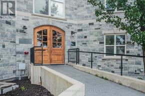Kingston (East Gardiners Rd) condo for rent - A stone building with a wooden door and windows.