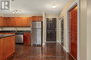 Kingston (East Gardiners Rd) condo for rent - A kitchen with wooden cabinets and a stainless steel refrigerator.
