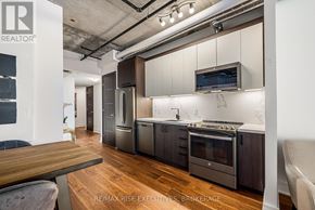 Ottawa condo for rent - A modern kitchen with dark wood cabinets and stainless steel appliances.