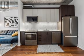Ottawa condo for rent - A modern kitchen with dark wood cabinets and stainless steel appliances.