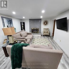 Barrie (Grove East) apartment for rent - A living room with a couch, a coffee table, and a TV.