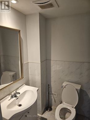 Ajax (Northwest Ajax) apartment for rent - A white toilet is in a bathroom with a sink and mirror.