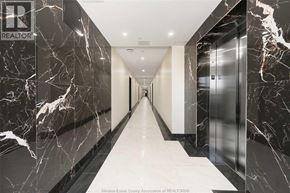 Windsor condo for rent - A hallway with marble floors and walls, and a sign that says REALTOR.