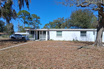 Jacksonville apartment for rent - A white house with a car parked in front.